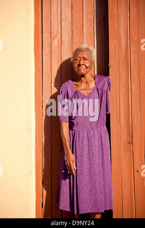 elderly woman in front of her home, Trinidad, Cuba, Caribbean Stock Photo