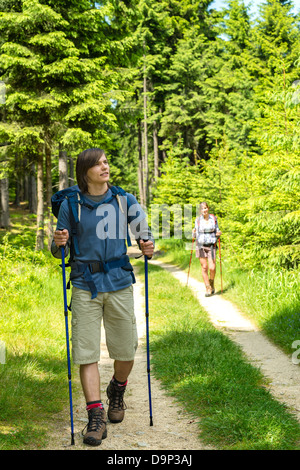 Teen hikers trekking in pine forest Stock Photo