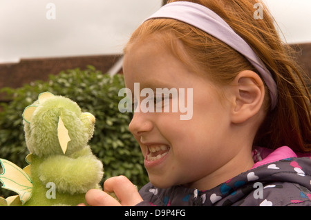 6 year old girl with a hand-made green dragon at a Teddy Bear Festival, Alton, Hampshire, UK. Stock Photo