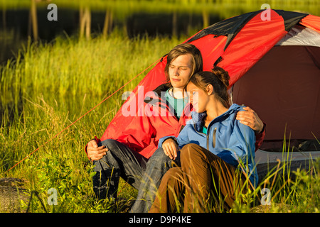 Camping couple hugging and enjoying the sunset Stock Photo