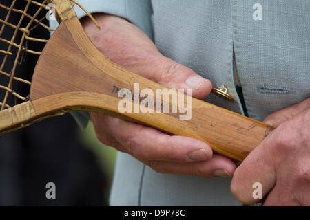 Wimbledon, London, UK. 24th June 2013. A tennis fan shows an  old wooden racket used by 7 times former champion William Renshaw as  large crowds queue on a cold overcast day at the 2013 Wimbledon tennis championships at the AELTC Credit:  amer ghazzal/Alamy Live News