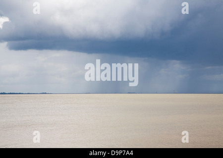 Heavy rain showers falling on sea from nimbocumulus cloud Orford Ness, North Sea, Suffolk coast, England Stock Photo