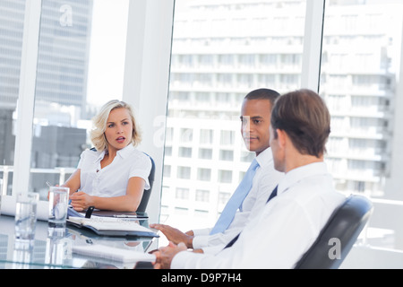 Concentrated businesswoman listening to colleagues Stock Photo