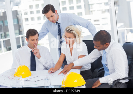 Four architects working on blueprints Stock Photo