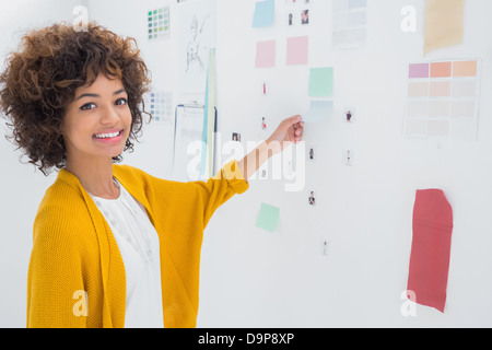 Cheerful designer standing in front of material samples Stock Photo