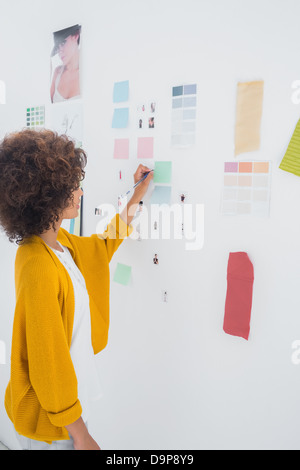 Female designer standing in front of material samples Stock Photo