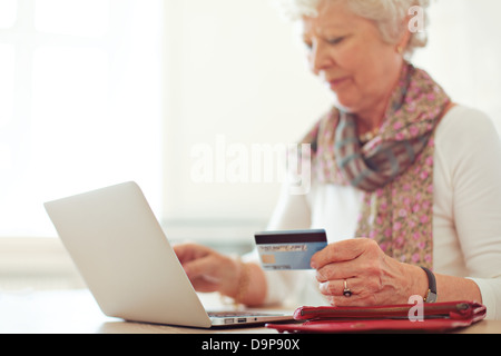 Grandmother using a credit card to make an online transaction Stock Photo