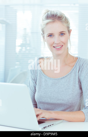 Blond haired woman using her laptop Stock Photo