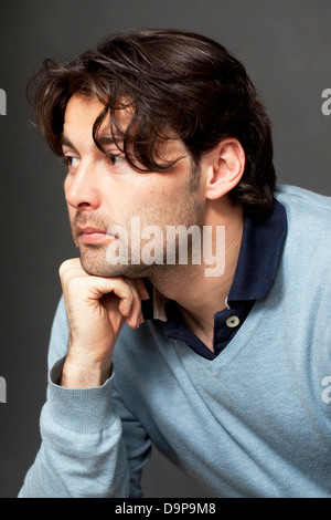 A brunette man with longer hair in blue pullover being depressed Stock Photo