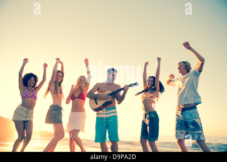 Friends playing guitar on the beach Stock Photo