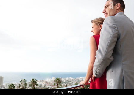 Lovely couple standing on their balcony Stock Photo