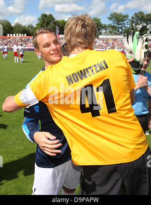 Basketball player Dirk Nowitzki (R) and German national goalkeeper Manuel Neuer hug before the charity soccer match between 'Manuel Neuer & Friends' and 'Nowitzki Allstars' in Wuerzburg, Germany, 23 June 2013. The proceeds from the event went to the project 'Soccer meets Culture' of the international LitCam campaign. Photo: DANIEL KARMANN Stock Photo