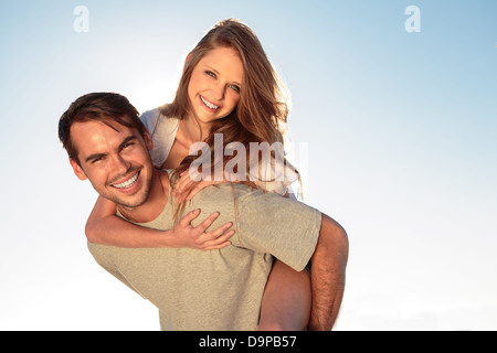 Man giving a piggy back to his girlfriend Stock Photo