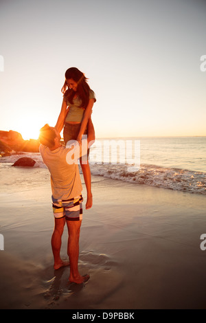 Man lifting his girlfriend at the beach Stock Photo - Alamy