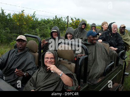 Tourists in an open land rover on a wet and windy day. Thanda game reserve, South Africa. Stock Photo