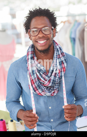 Fashion designer standing with a measuring tape Stock Photo