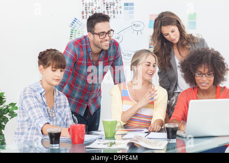 Team of creative designers working on a laptop Stock Photo