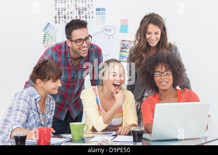 Cheerful team of creative designers working on a laptop Stock Photo