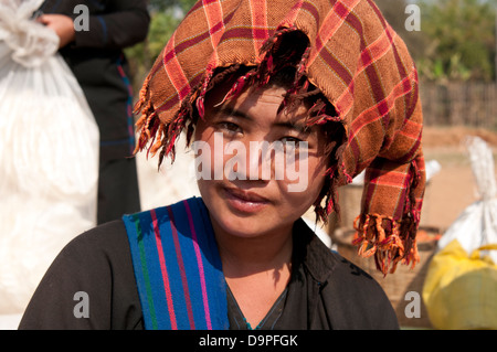 Young Pa-O woman wearing orange checked traditional headdress smiling at the camera in a market Myanmar (Burma) Stock Photo