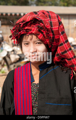 Young Pa-O woman wearing red checked traditional headdress smiling at the camera in a market Myanmar (Burma) Stock Photo