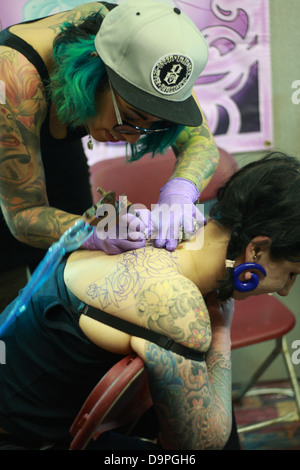 Tattooist working at Brighton tattoo convention Stock Photo