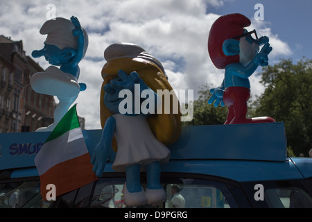 Three figurines of smurfs on top of a promotional car. Stock Photo