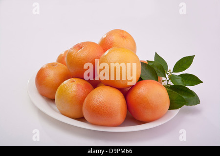 group of fresh ruby red grapefruits cut and whole Stock Photo