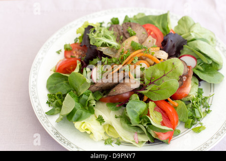 Delicious salad with fried rabbit liver and fresh vegetables. Stock Photo