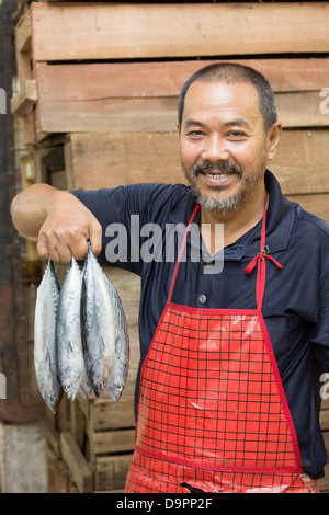 Fish monger holding up fish, Central Market, Kota Bharu, Kelantan, Malaysia Stock Photo