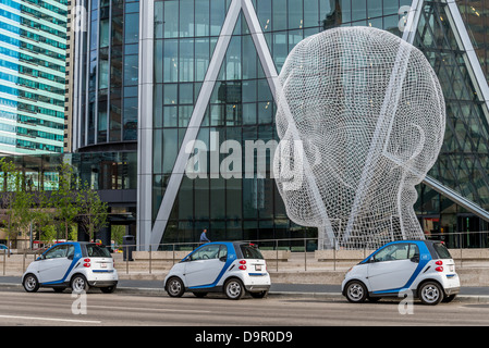 Car2Go rental cars and sculpture titled 'Wonderland' by Jaume Plensa. The Bow Tower, Calgary, Alberta, Canada Stock Photo