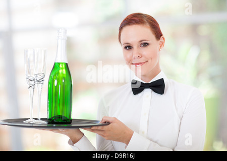 pretty young waitress serving champagne in restaurant Stock Photo