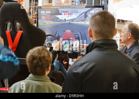 Visitors of ProfiAuto Show 2013, Katowice, Poland, watching on driving simulator. Stock Photo
