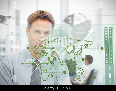 Businessman looking at green map interface Stock Photo