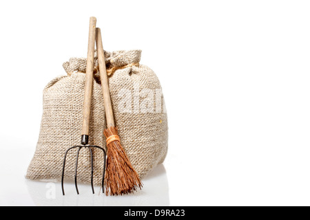 Bags with potatoes and agricultural tools on a white background Stock Photo