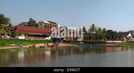 Horizontal panoramic (2 picture stitch) view of the riverside hotels and bars along the Nam Song river in Vang Vieng. Stock Photo