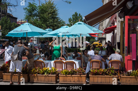 Patrons sit at the outdoor cafe of the Chez Lucienne restaurant on Lenox Avenue in Harlem Stock Photo