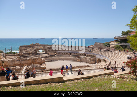 Tourists around Roman amphitheatre Tarragona and tanker ships in distance Stock Photo