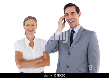 Smiling businessman on the phone next to his colleague Stock Photo