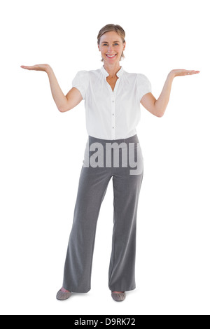 Smiling businesswoman presenting something with her two hands raised Stock Photo