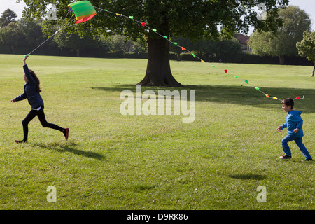 Kids flying a kite in the park Stock Photo