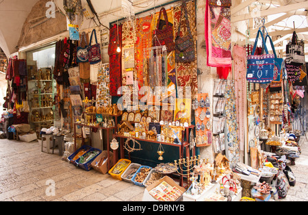 Israel Jerusalem Old City street scene Jewish Muslim Arab Christian tourist memorabilia souvenir shop stall in street scene covered market souk Stock Photo