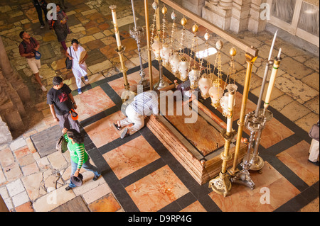 Israel Jerusalem Old City Church of the Holy Sepulcher Sepulchre Stone of the Unction body of Christ anointed wrapped worshipers kneeling in prayer Stock Photo