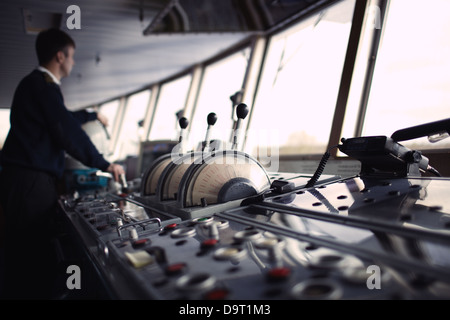 Navigation officer driving ship on the river. Stock Photo