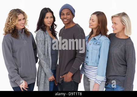 Fashionable young people in a row all looking at man Stock Photo
