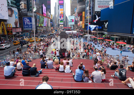 CROWD SITTING ON RED STEPS TKTS CENTER TIMES SQUARE MIDTOWN MANHATTAN NEW YORK CITY USA Stock Photo