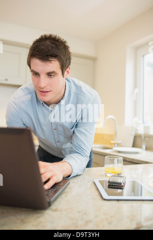Man at the notebook with smartphone and tablet Stock Photo