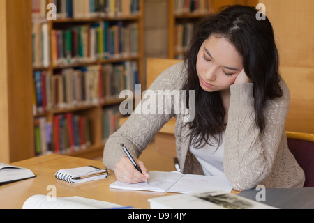 Bored student in a library learning Stock Photo