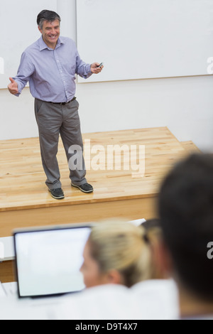 Explaining teacher standing in a lecture hall Stock Photo
