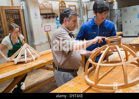 Teacher helping a student in a woodwork class Stock Photo