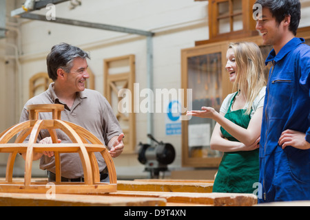 Students and teacher talking and laughing in woodwork class Stock Photo